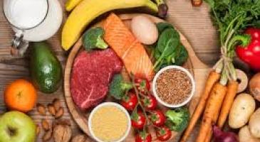 Array of fruits, raw vegetables, meat and mile on wooden surface