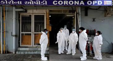 Healthcare workers stand at the entrance of a Covid-19 hospital in Ahmedabad in January 2022. Photograph: Amit Dave/Reuters