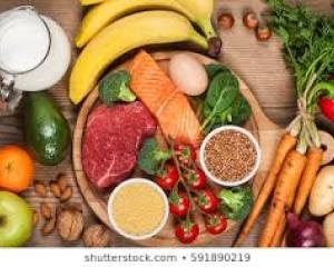 Array of fruits, raw vegetables, meat and mile on wooden surface