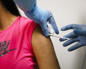 Health worker injects a person during clinical trials for a COVID-19 vaccine at Research Centers of America in Hollywood, Fla., on September 9, 2020.