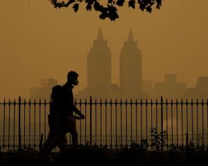 People walk in Central Park fire haze on Wednesday.