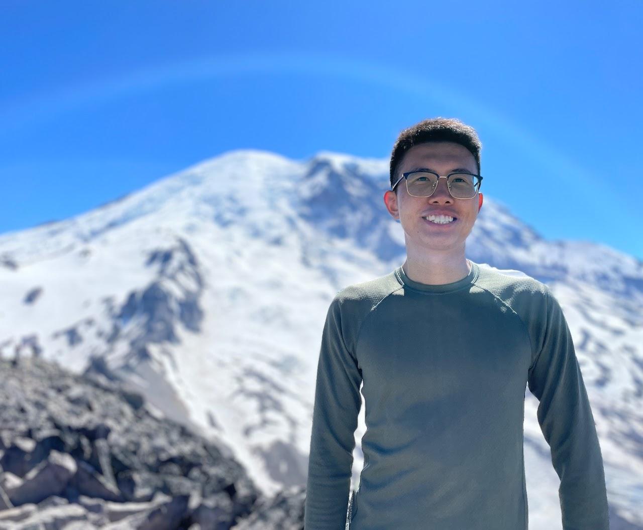 Photo of Xiudi Li standing in front of snowy peak